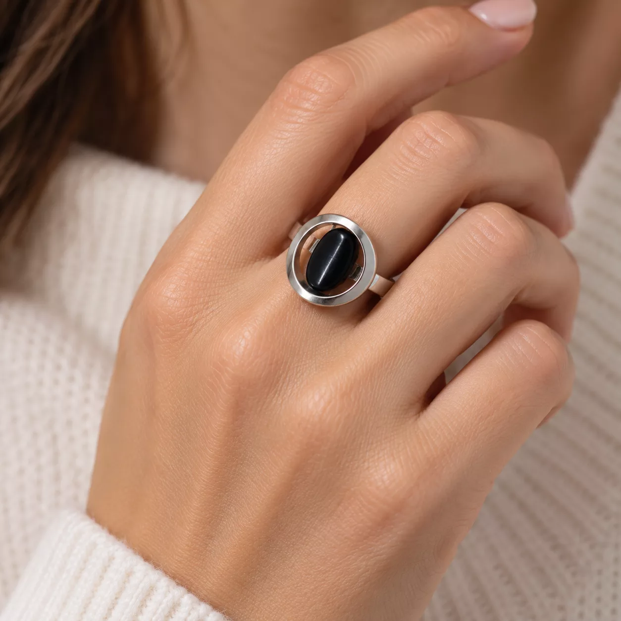Bague Éclipse portée sur la main avec élément central bleu marine presque noir