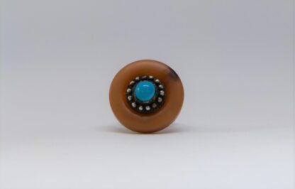 Bague au plateau imitation corne et perle couleur turquoise.