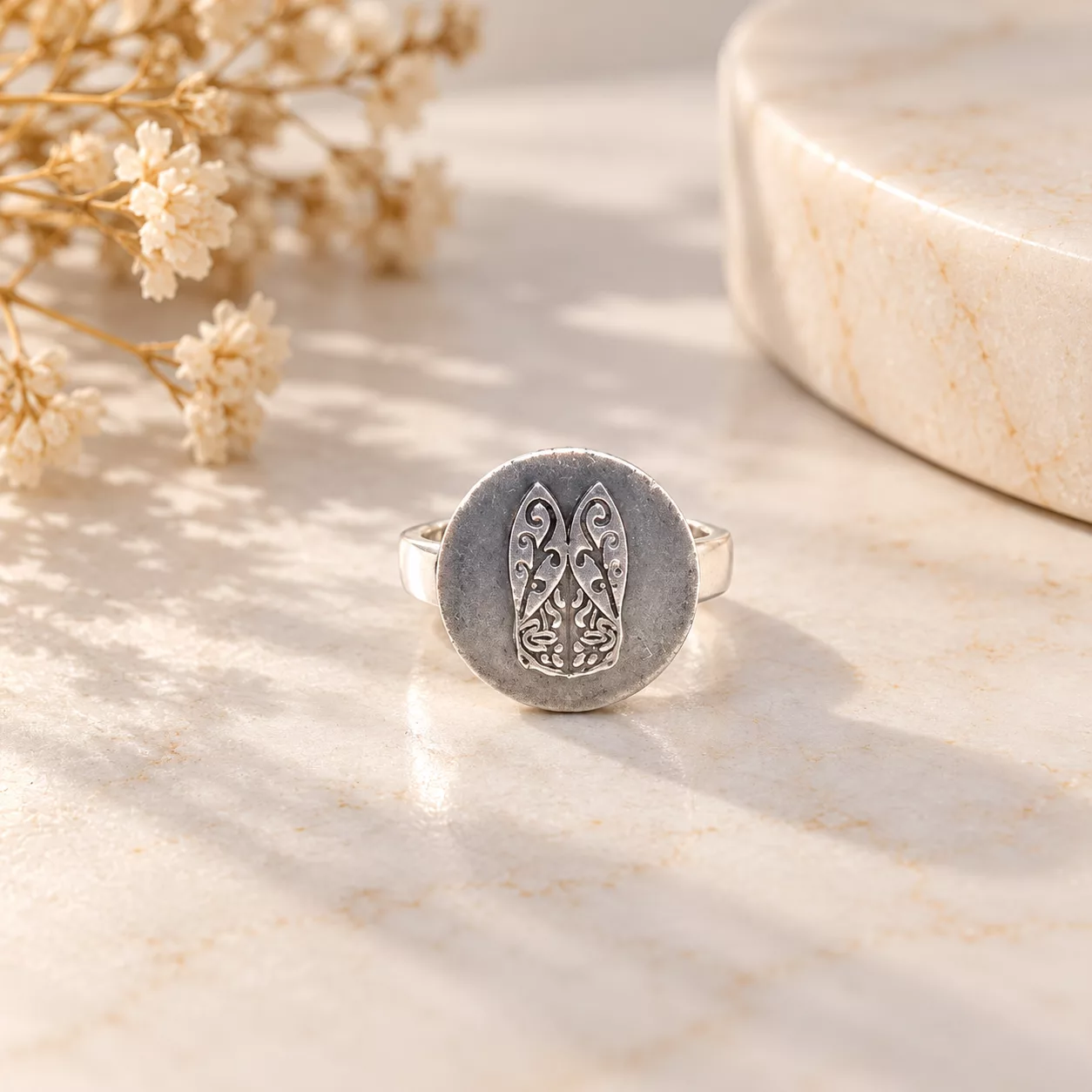 Vue de face de la bague Cigale montrant le motif stylisé et ses arabesques