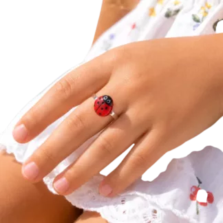Bague enfant coccinelle réglable créée à partir d'un ancien bouton, portée par une petite fille