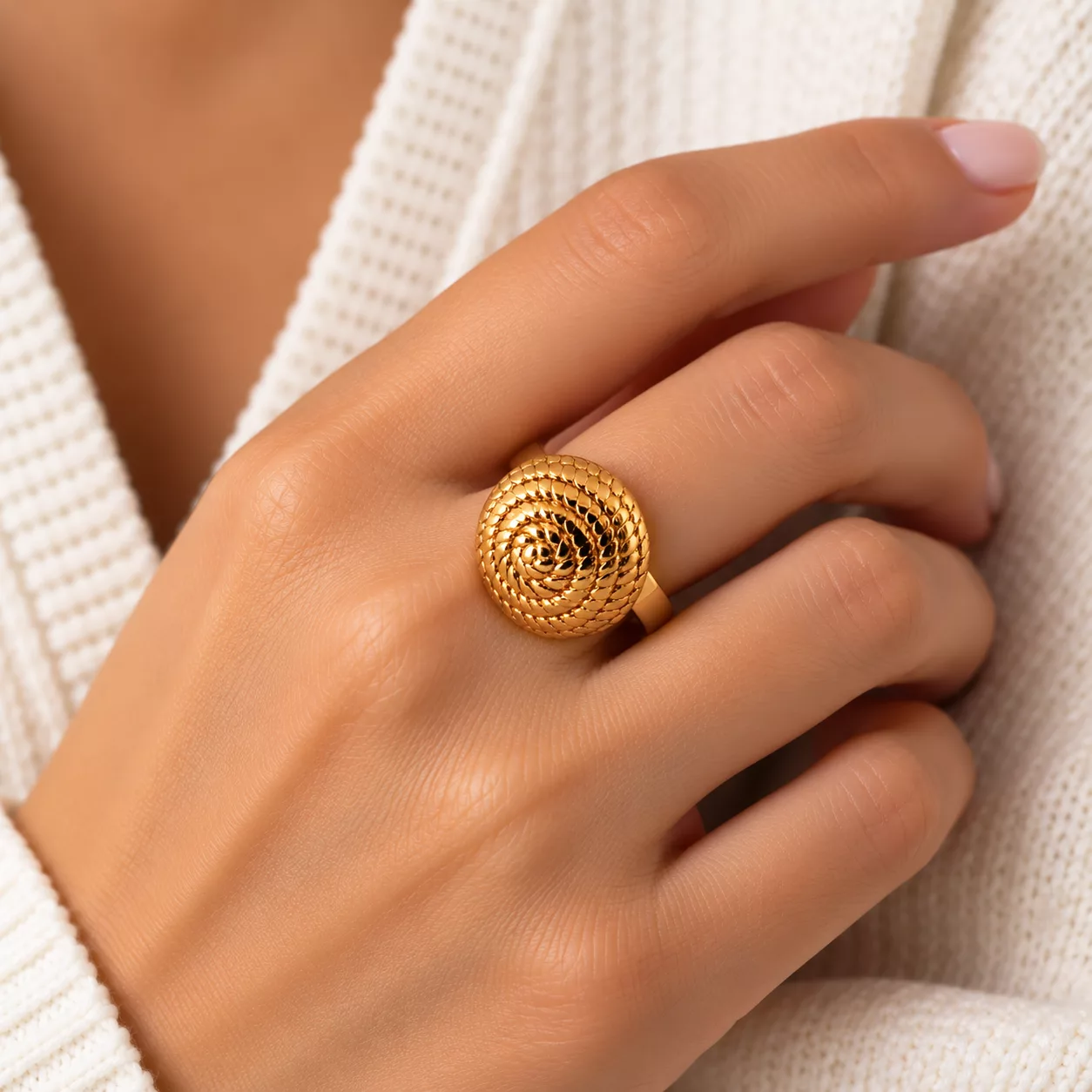 Bague dorée motif spirale Tourbillon portée à la main, avec son décor circulaire finement texturé