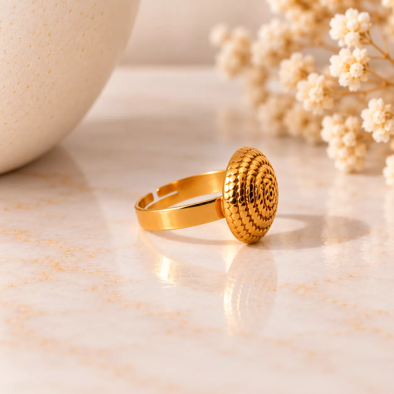 Vue de profil de la bague Tourbillon montrant sa surface dorée texturée et son anneau ajustable
