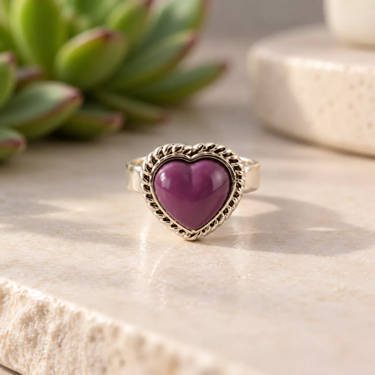 Vue de face de la bague Cœur violet montrant le cœur bombé et sa bordure argentée travaillée