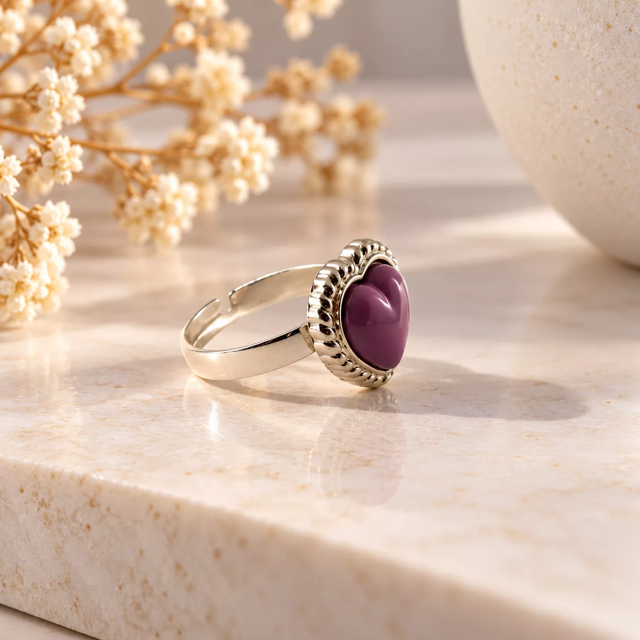 Vue de profil de la bague Cœur violet montrant le relief du bouton et l'anneau argenté ajustable