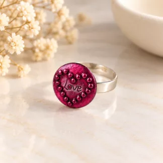Bague Love bordeaux créée à partir d'un ancien bouton, avec cœur perlé sur fond crème