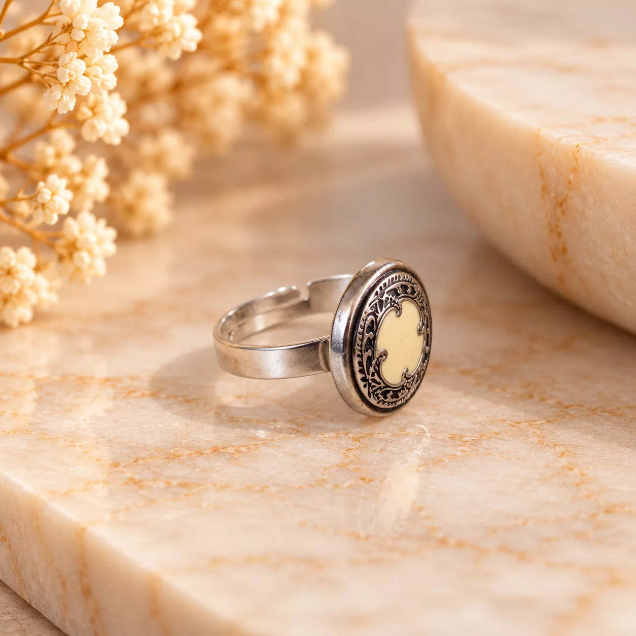 Vue de profil de la bague Aura avec ancien bouton ouvragé et support argenté