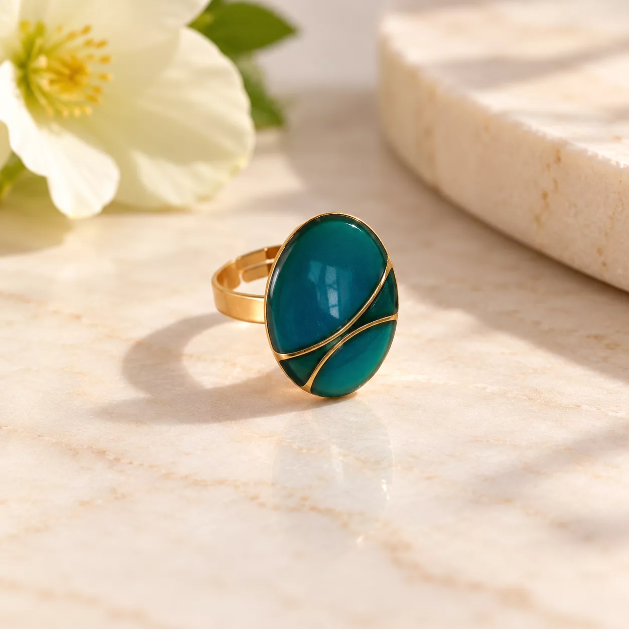 Vue de face du bouton ovale turquoise avec deux lignes dorées courbes