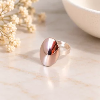 Bague ovale effet miroir en métal argenté avec anneau ajustable sur fond crème