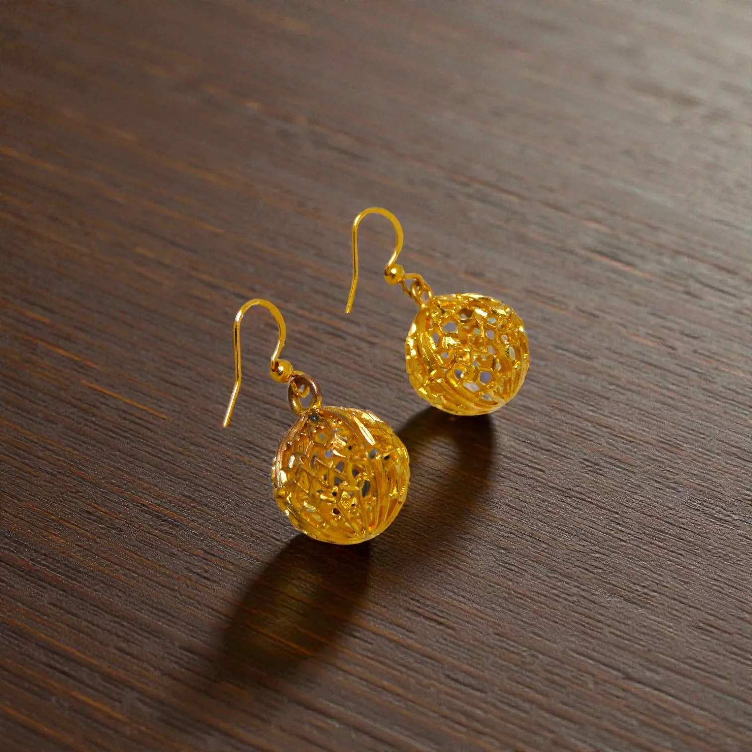 boucles d'oreilles en forme de sphères ajourées dorées