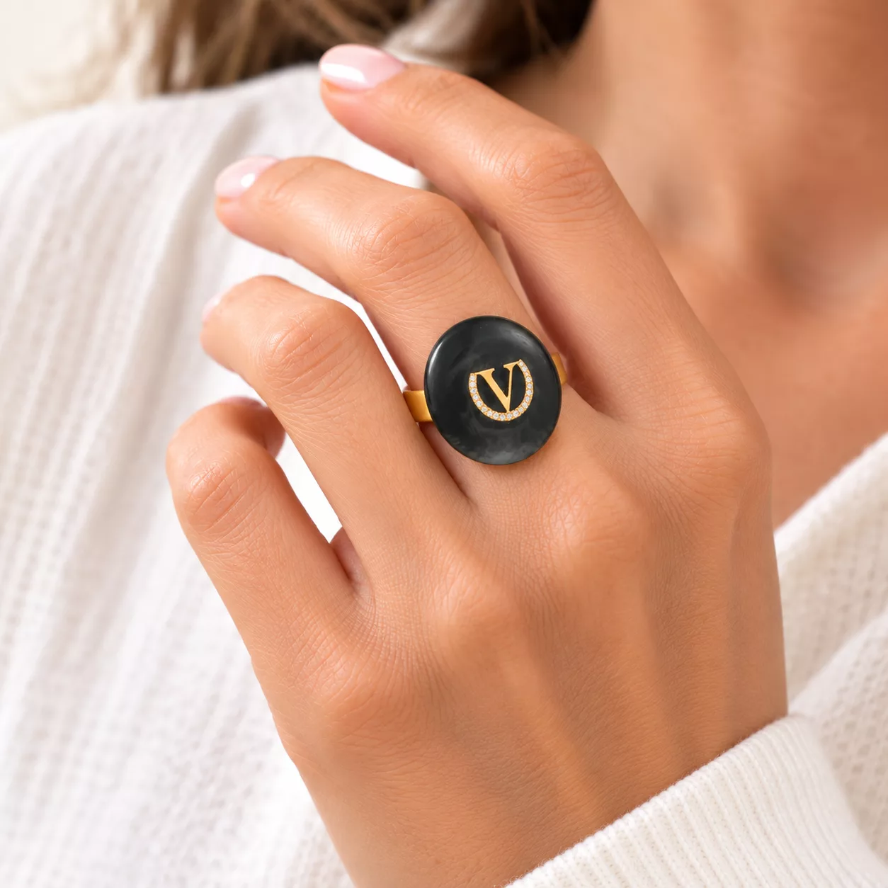 Bague Le V portée au doigt, médaillon rond gris anthracite marbré et motif doré