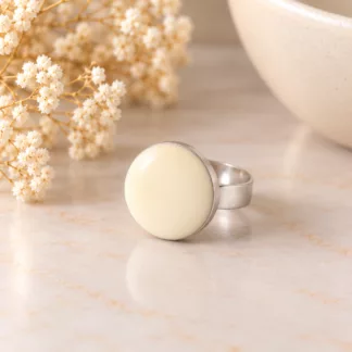 Bague Ivoire minimaliste avec bouton rond crème sur fond clair élégant
