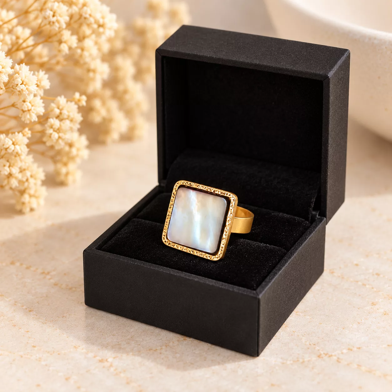 Bague Nacre carrée dorée présentée dans une boîte cadeau noire