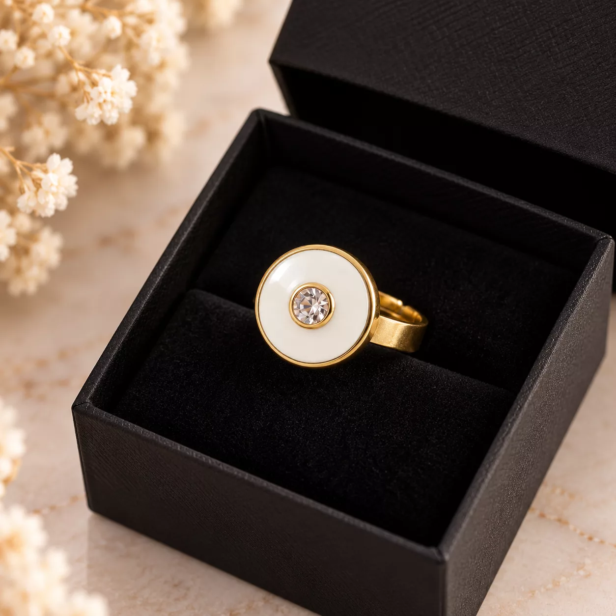 Bague Albane blanche et dorée présentée dans une boîte cadeau noire