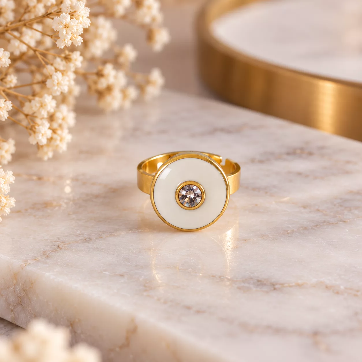Vue de face de la bague Albane avec son ancien bouton blanc cerclé de doré et son strass central