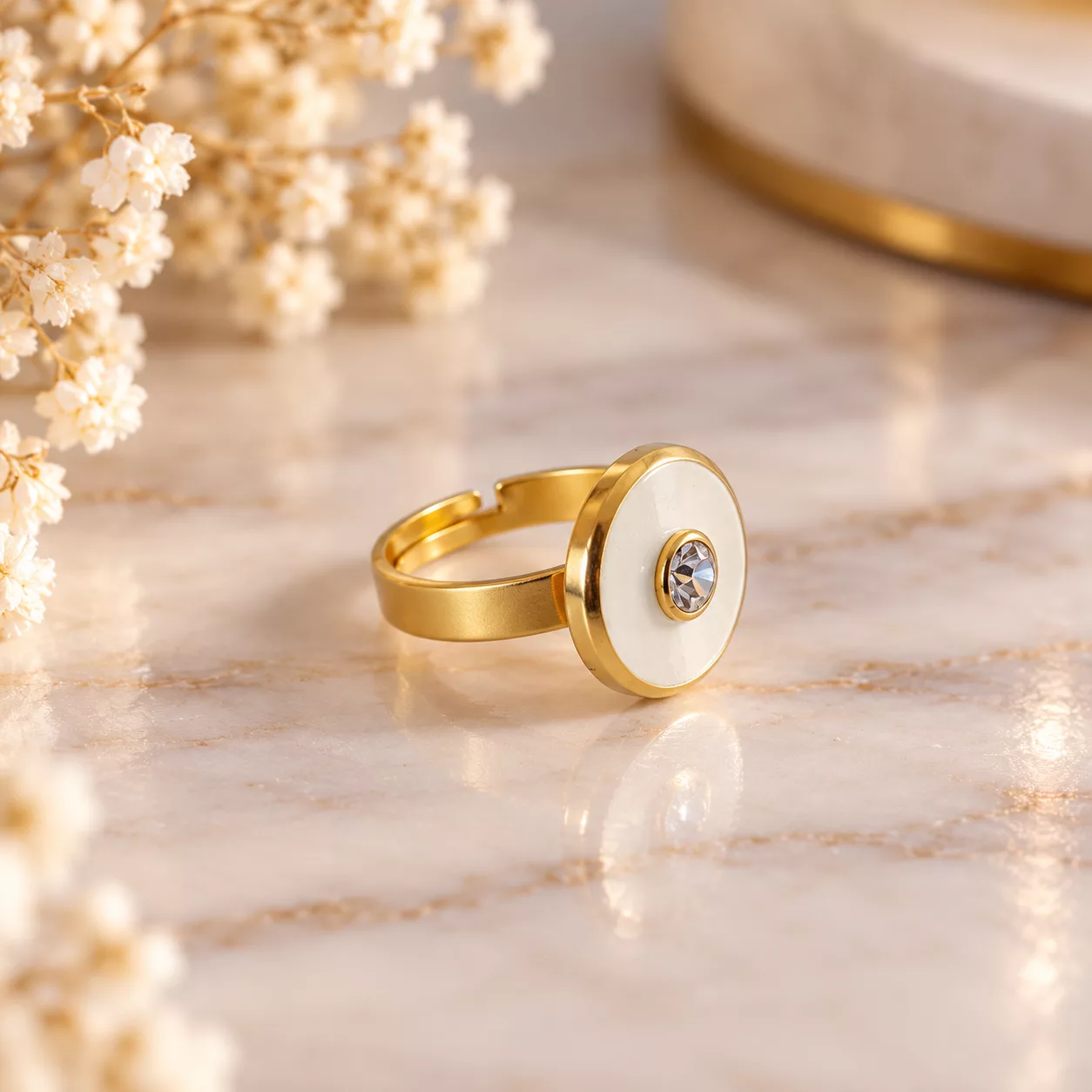 Vue de profil de la bague Albane montrant son motif rond blanc et son anneau doré ajustable