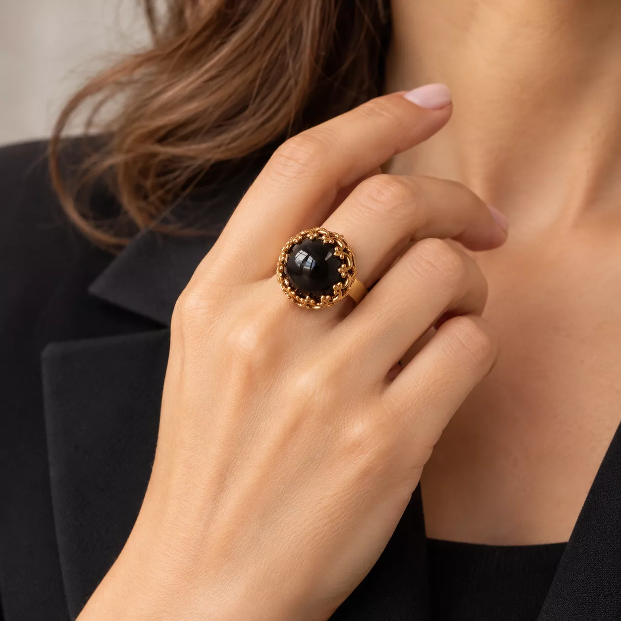 Bague Arabesque portée sur la main, cabochon noir bombé et ornements dorés