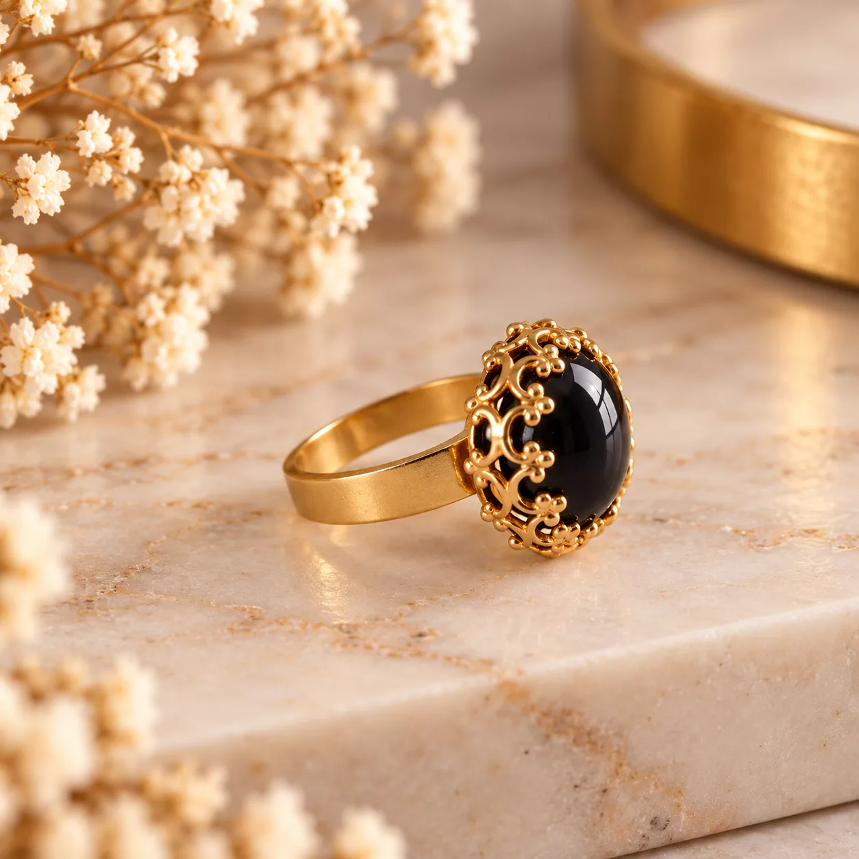Vue de profil de la bague Arabesque montrant son cabochon bombé et son entourage doré ouvragé