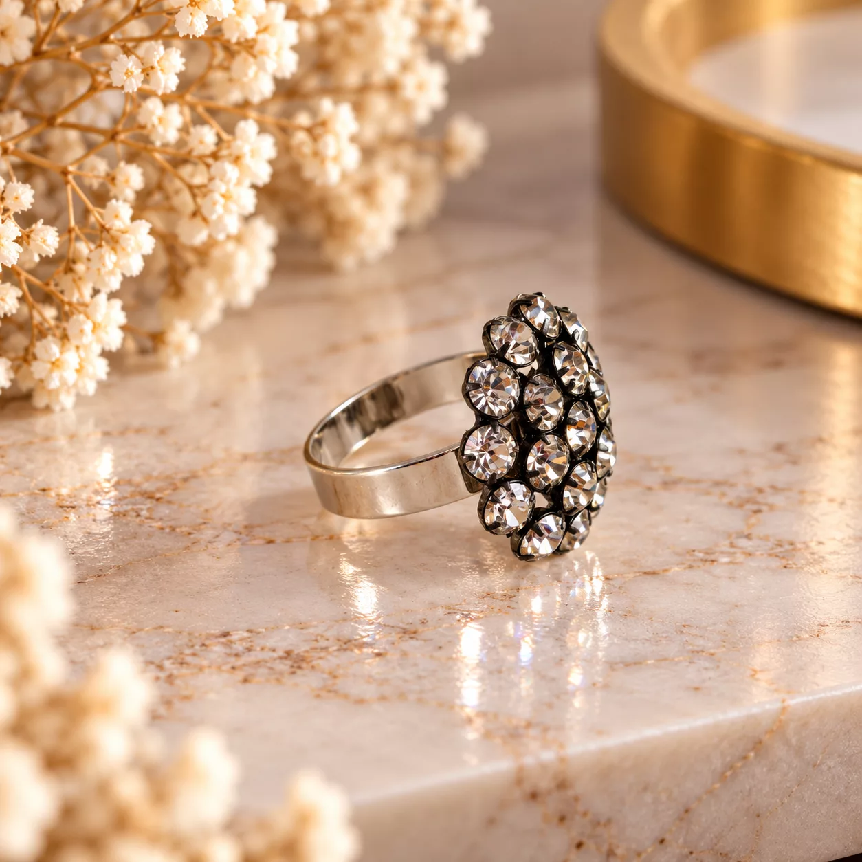 Vue de profil de la bague Astrée avec son motif bombé à strass et son support doré