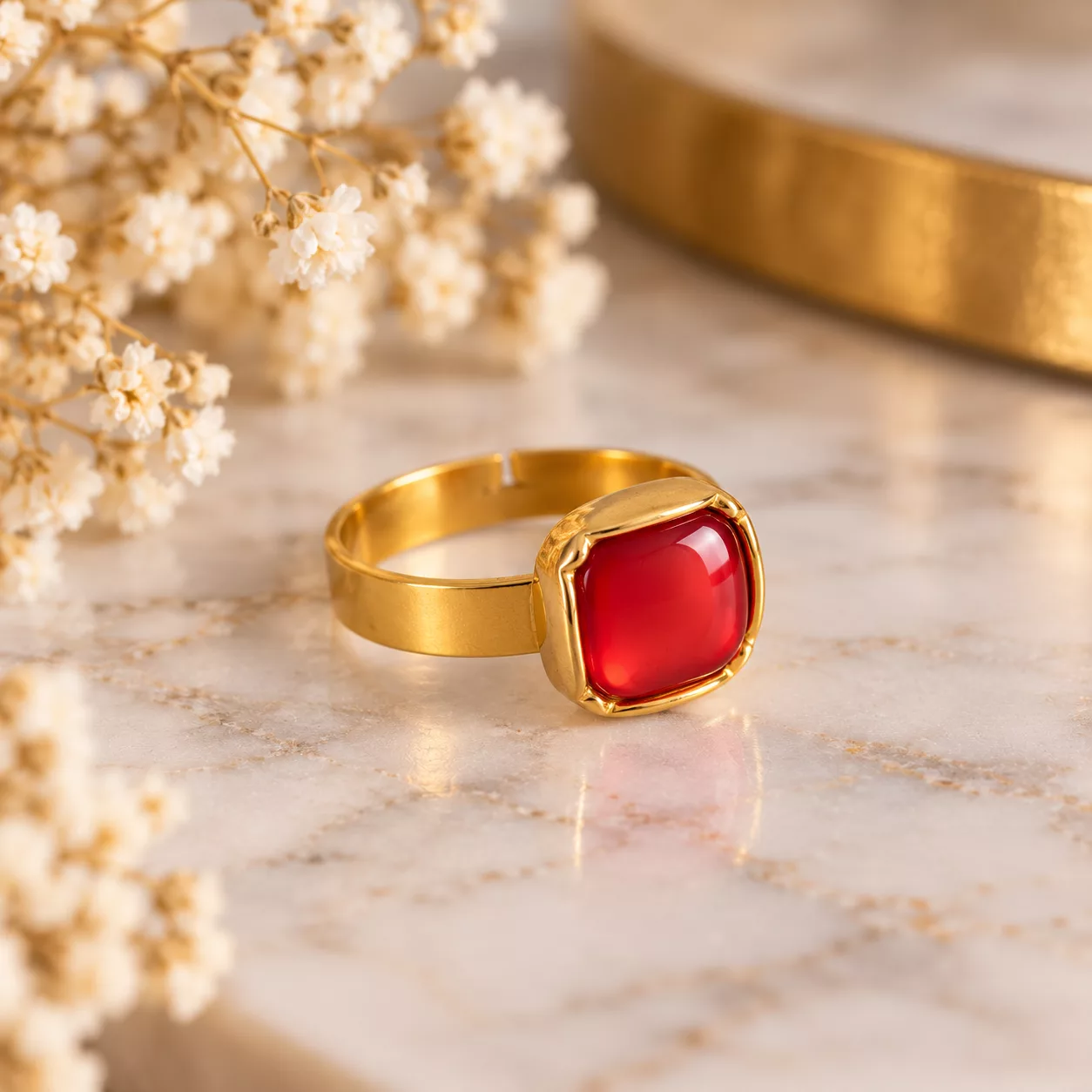 Vue de profil de la bague Carmen avec son bouton rouge et son support doré à l'or fin 24 carats