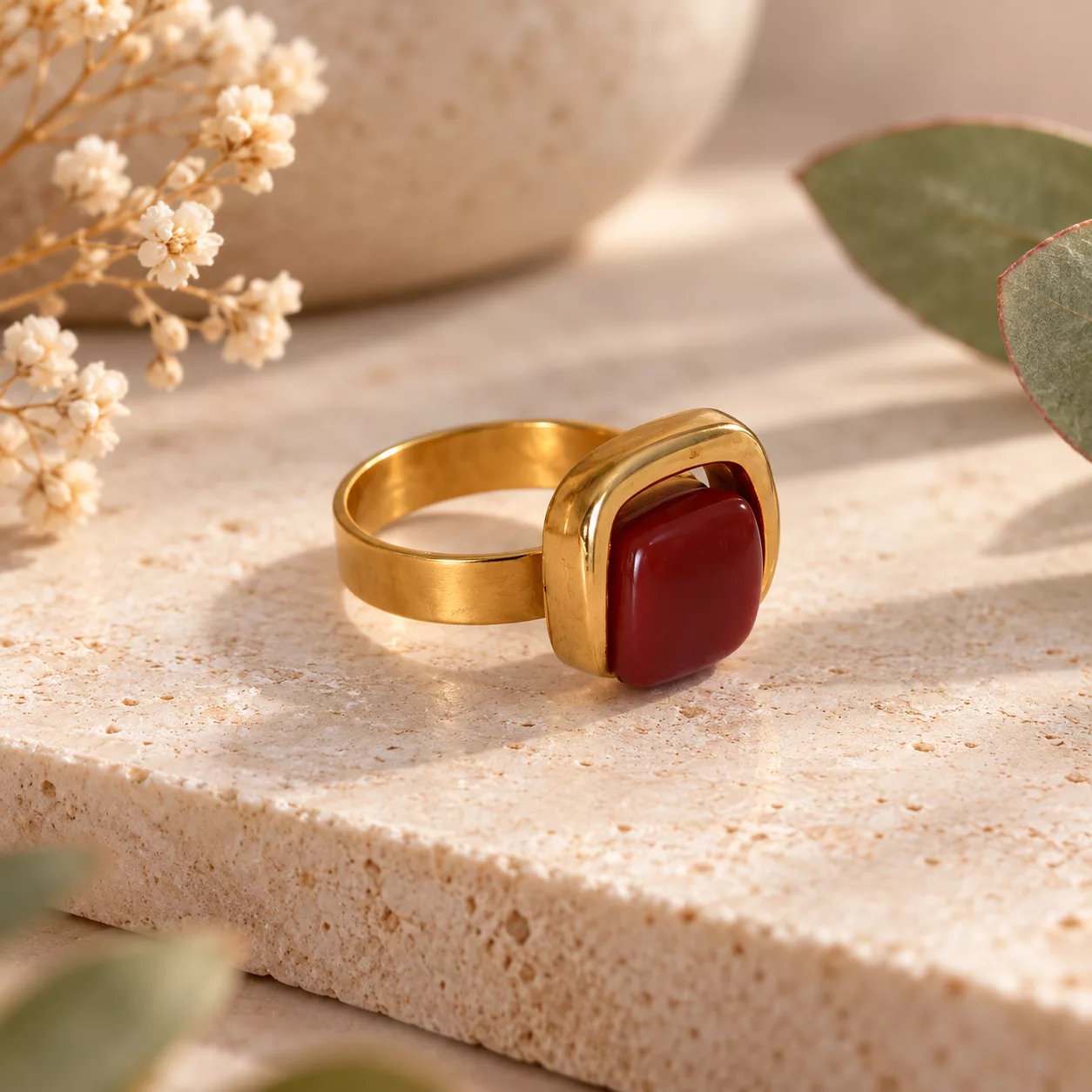 Bague Gina marron et dorée présentée dans un décor de plantes succulentes