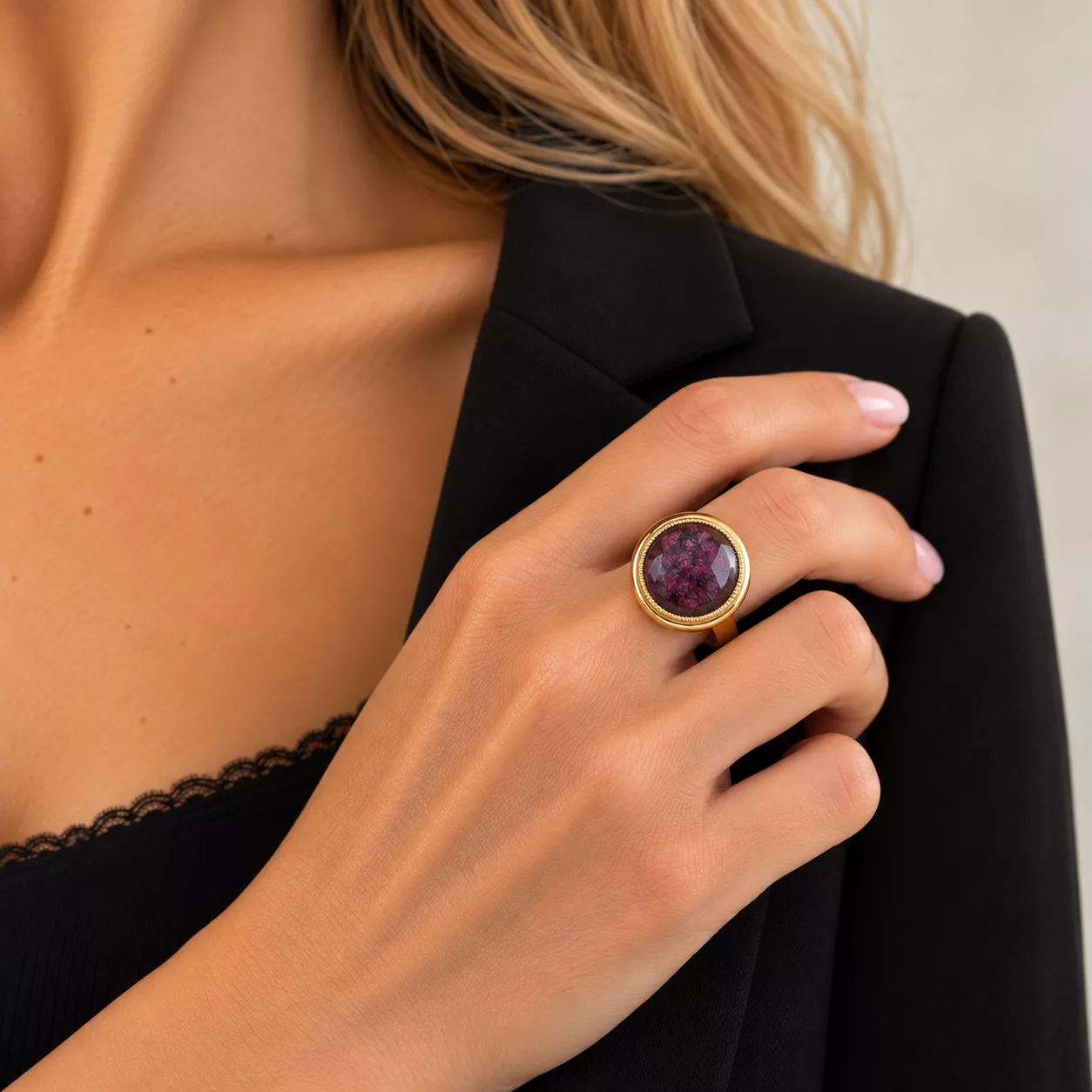 Bague Prunelle portée au doigt avec son bouton rond prune et sa bordure dorée