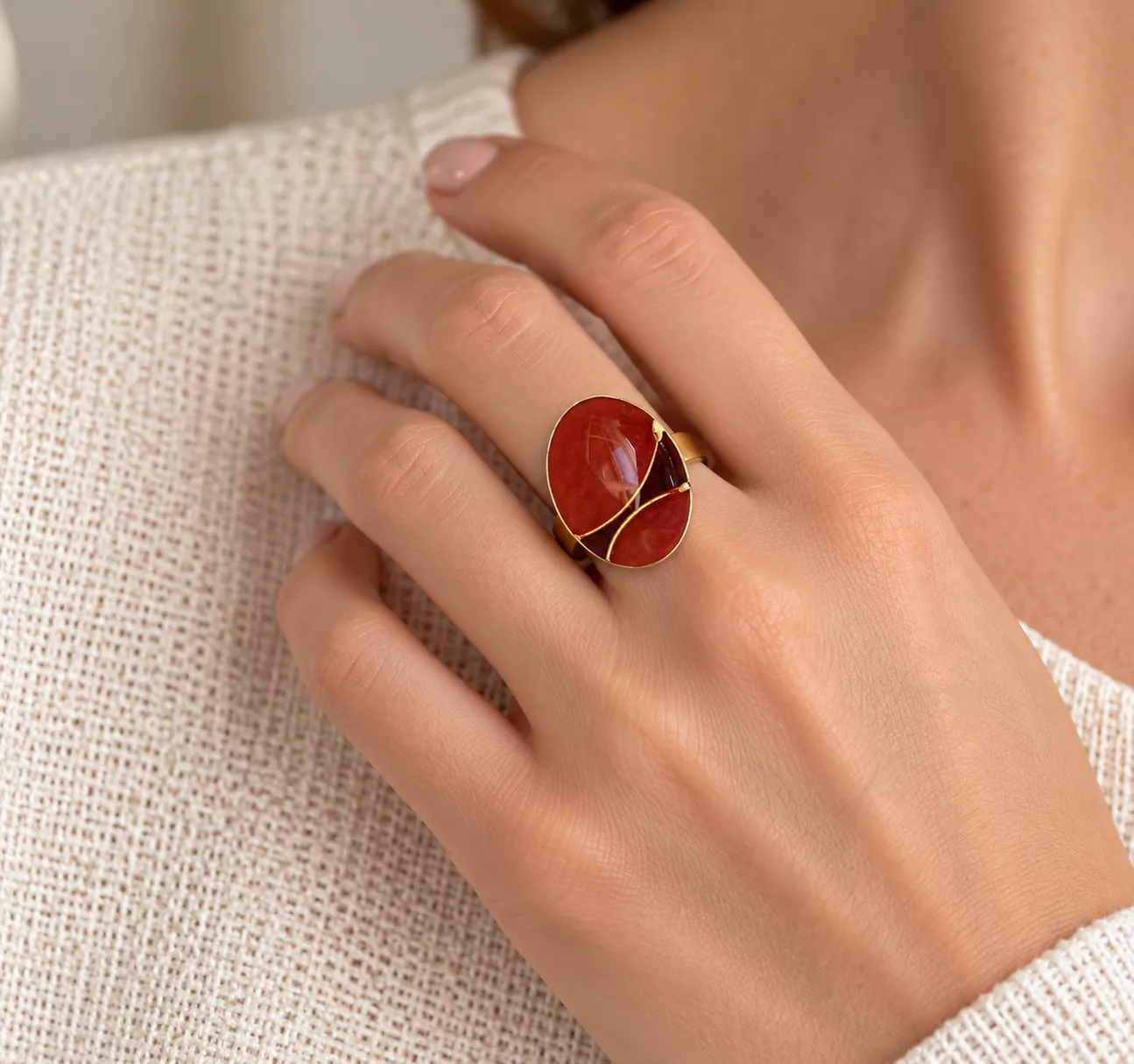 Bague Sienne portée sur la main, avec bouton ovale marron orangé et décor doré