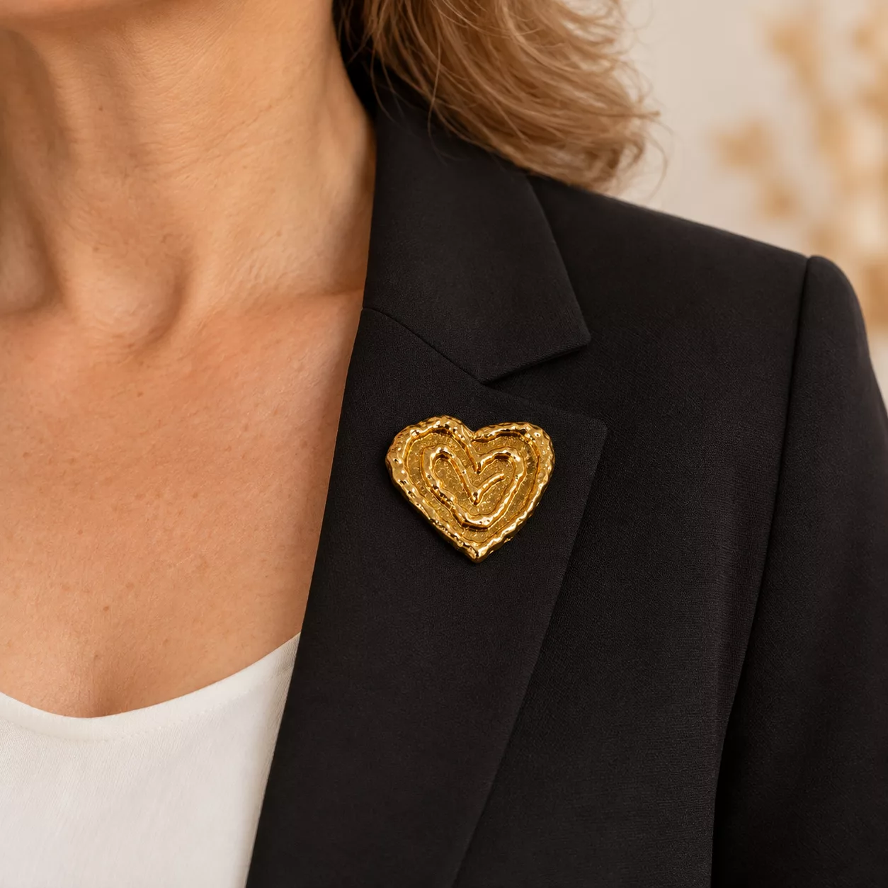 Broche Cœur Graphique dorée portée sur une veste noire